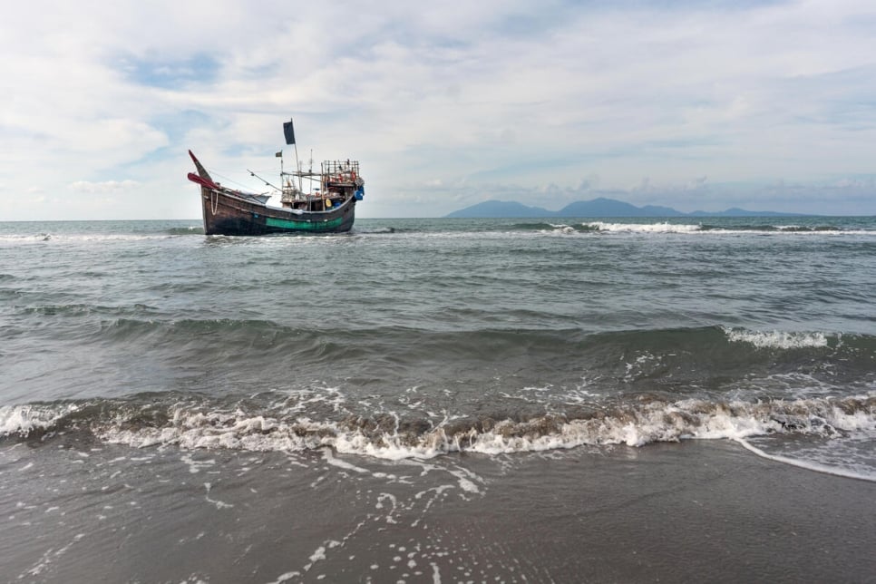 A boat that carried Rohingya refugees across the Andaman Sea remains anchored offshore after the refugees disembarked at a beach in Aceh, Indonesia on 8 January, 2023.